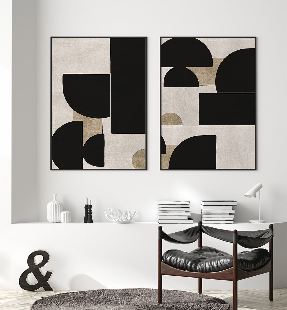 Two abstract art pieces on a wall above a dining table with chairs.
