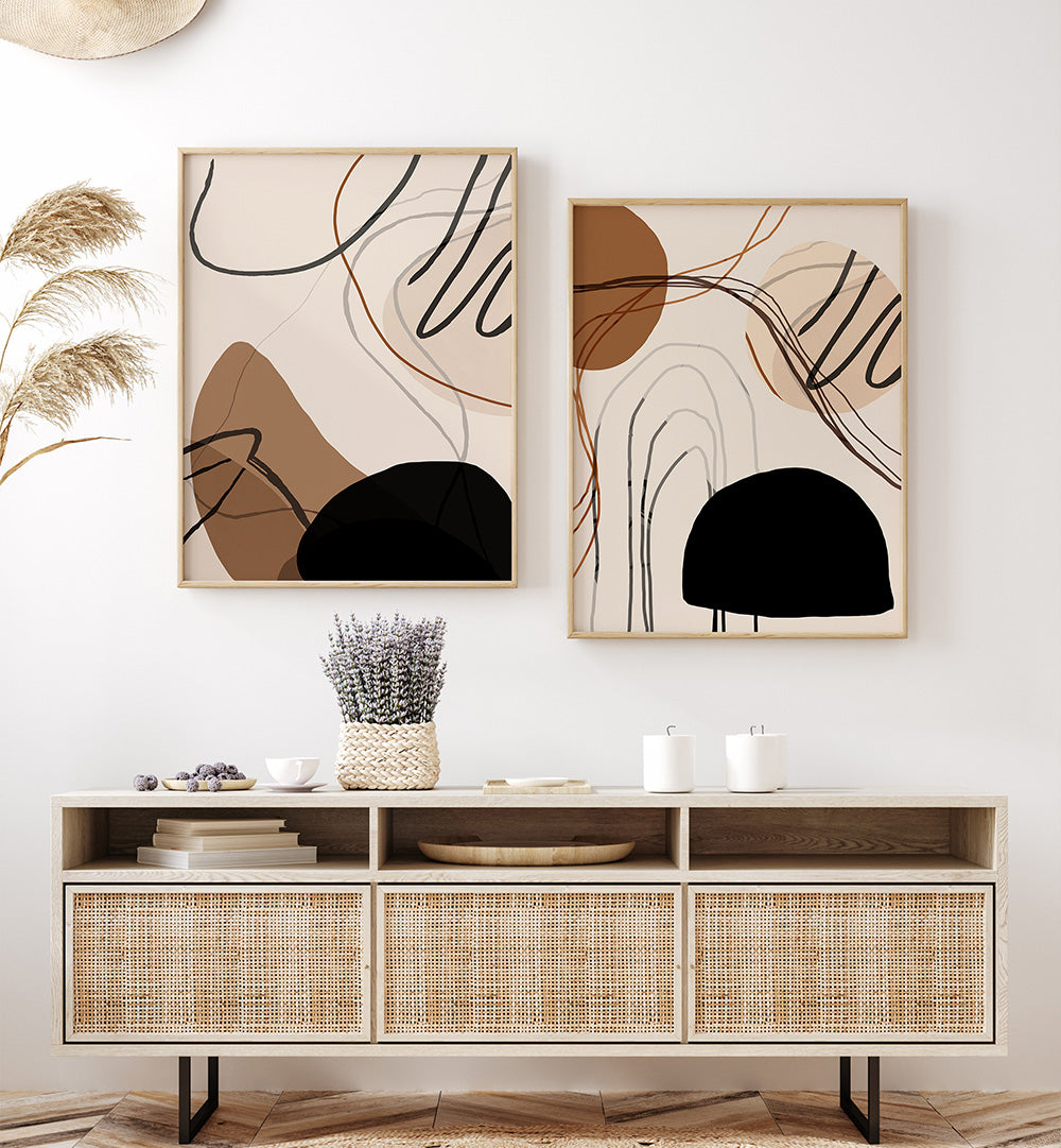 Two abstract wall art pieces above a wooden console table with decorative items.