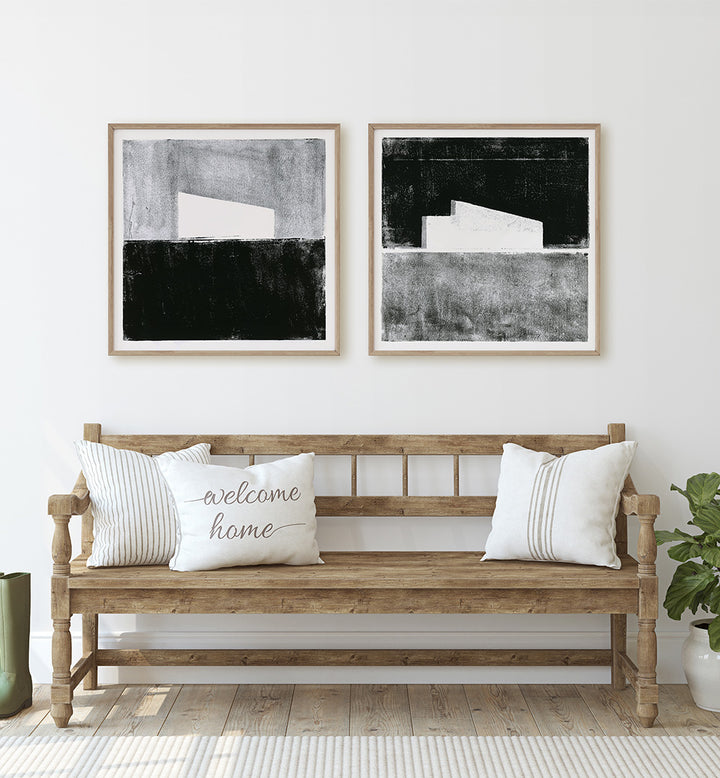 Wooden bench with decorative pillows and framed abstract art in a room.