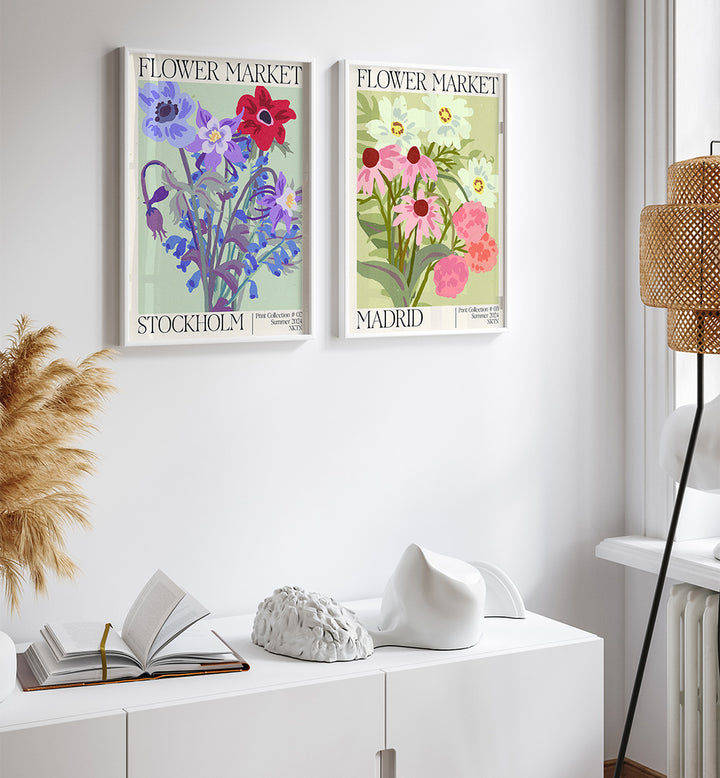 Two floral posters titled 'Flower Market Stockholm' and 'Flower Market Madrid' on a white wall above a white cabinet.