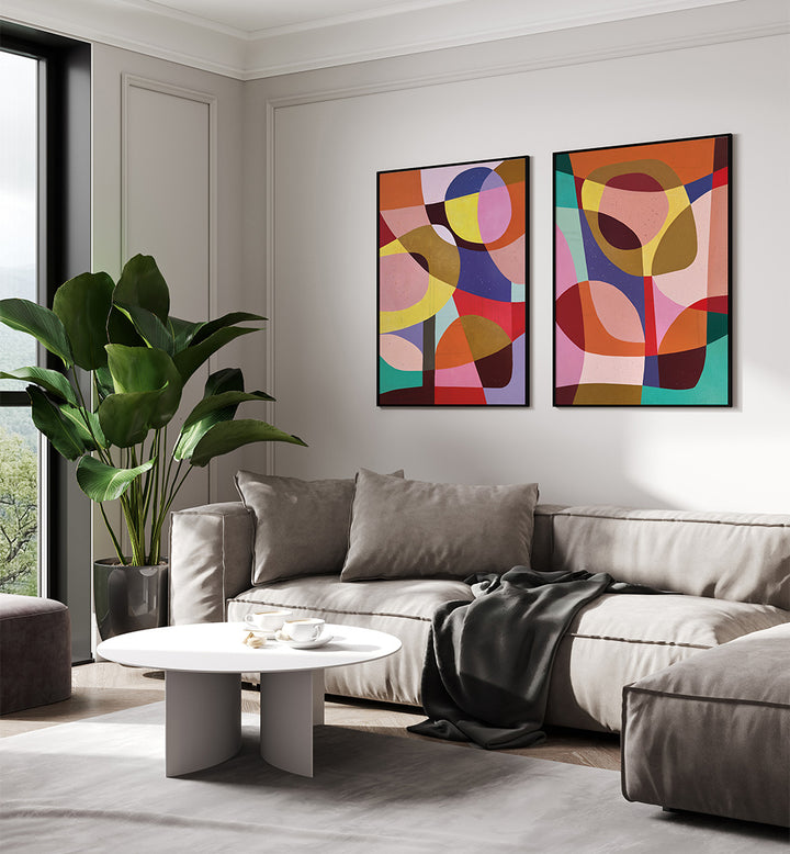 Modern living room with a gray sofa, round coffee table, and abstract colorful paintings on the wall.