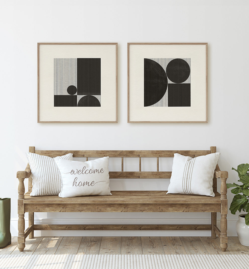 Wooden bench with pillows and framed abstract art on a white wall