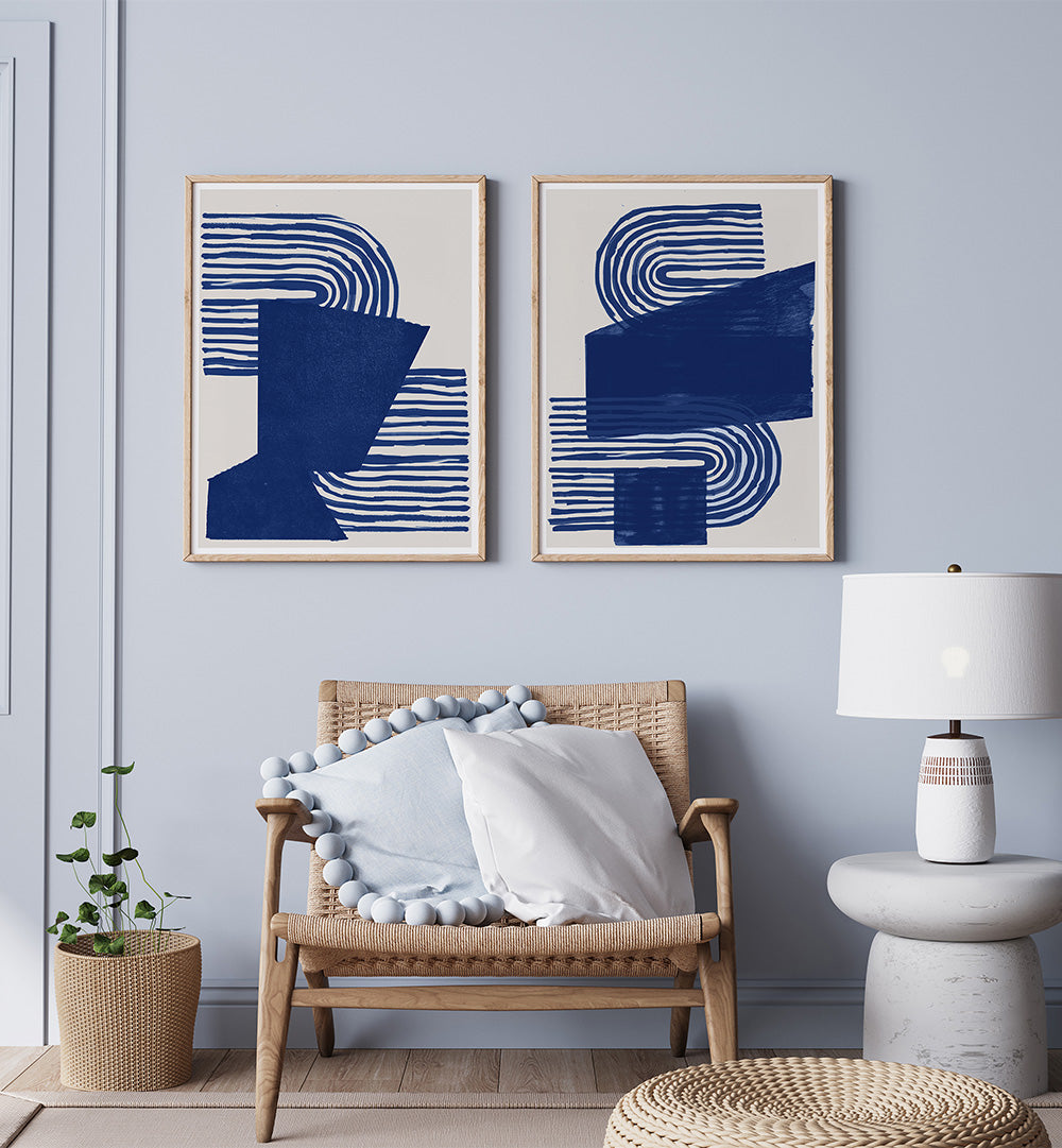 Modern living room with abstract blue and white wall art, wicker chair, and side table.