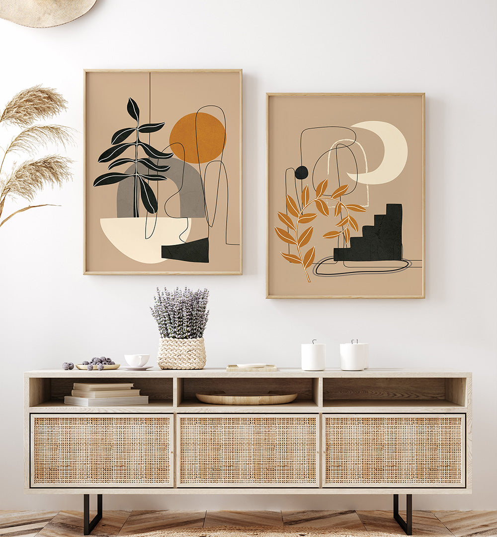 Two abstract wall art pieces above a wooden console table with decorative items.