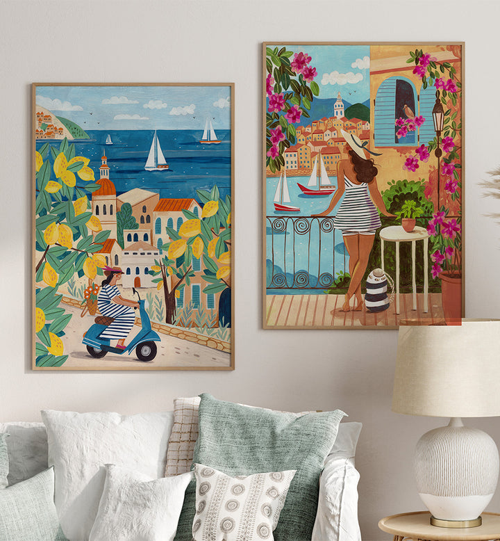 Two colorful paintings of Mediterranean scenes on a wall above a sofa.