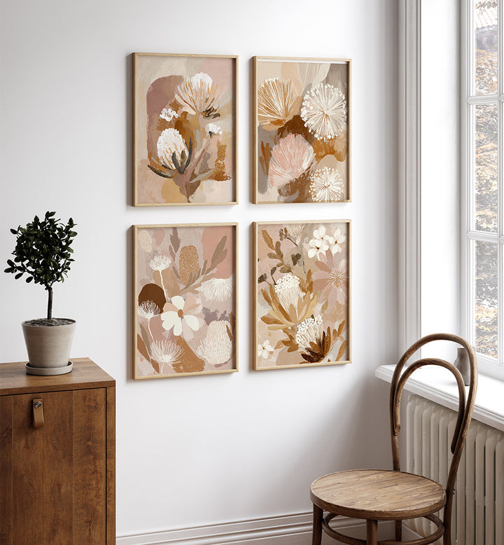 Four floral framed artworks on a wall with a wooden cabinet and chair in the foreground.