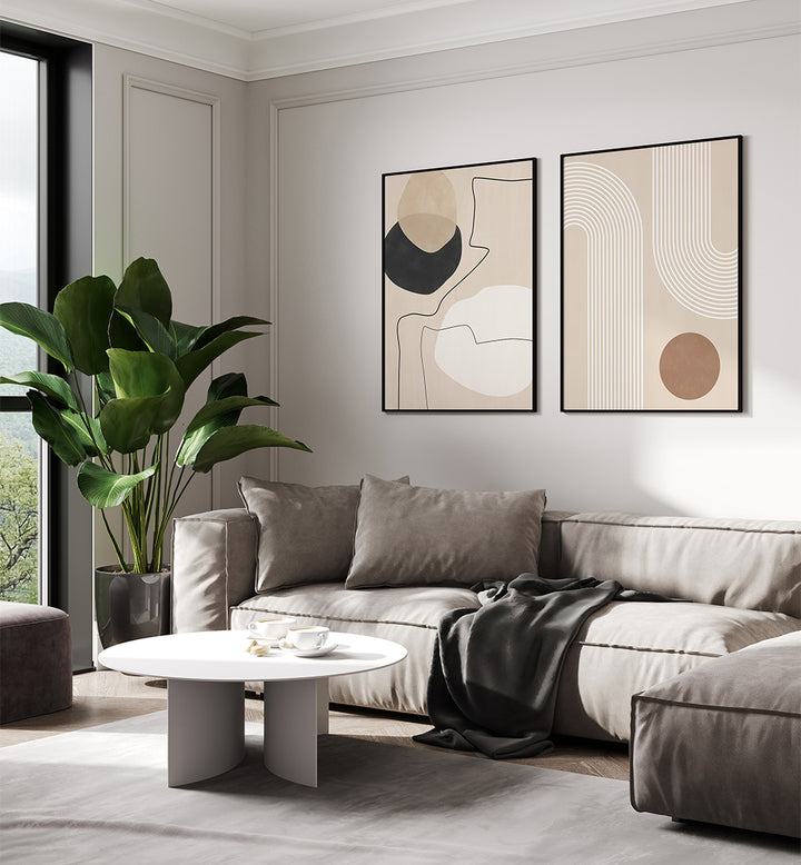 Modern living room with a gray sectional sofa, abstract art on the wall, and a plant.