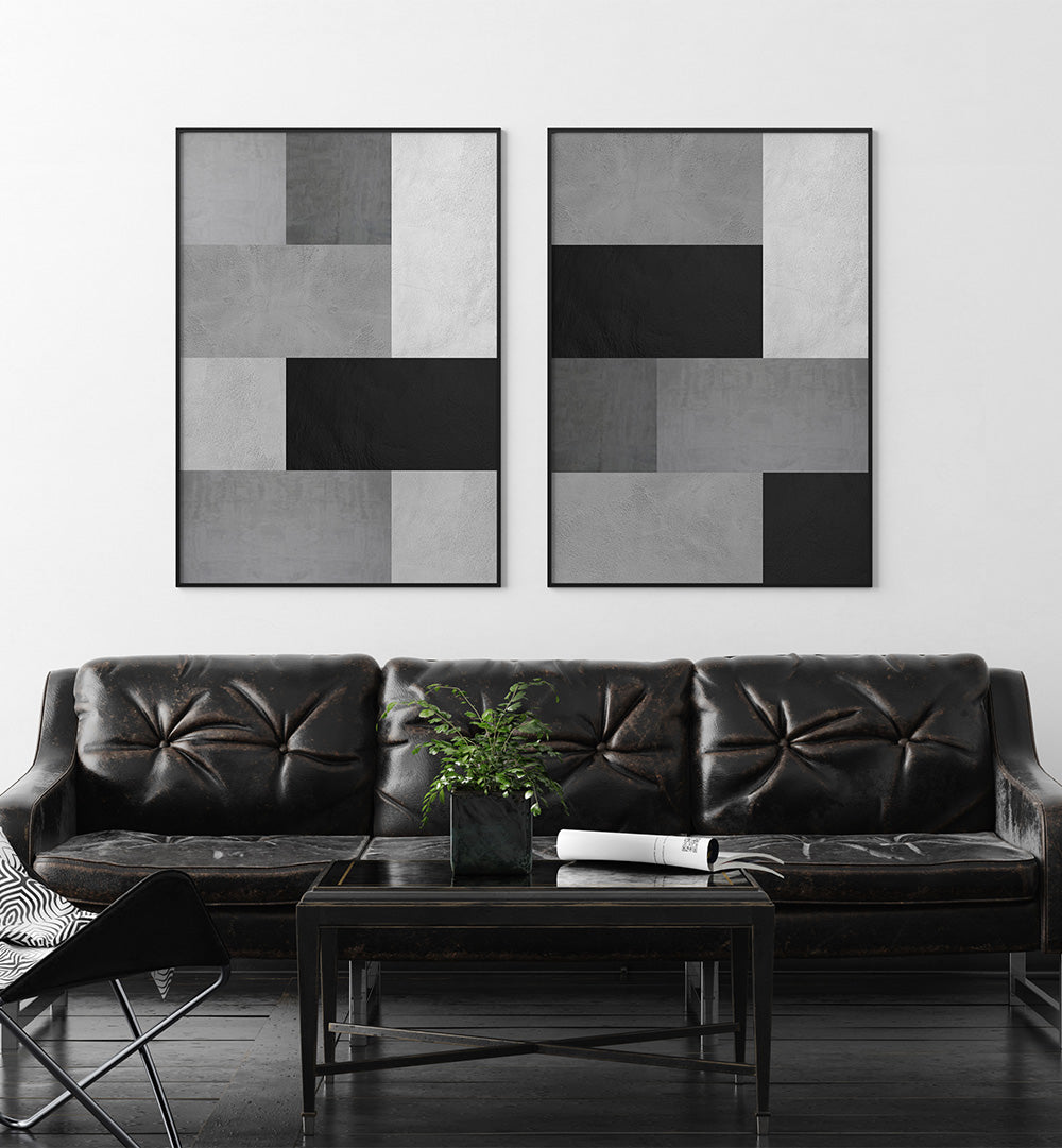 Modern living room with a black leather sofa, coffee table, and abstract wall art.