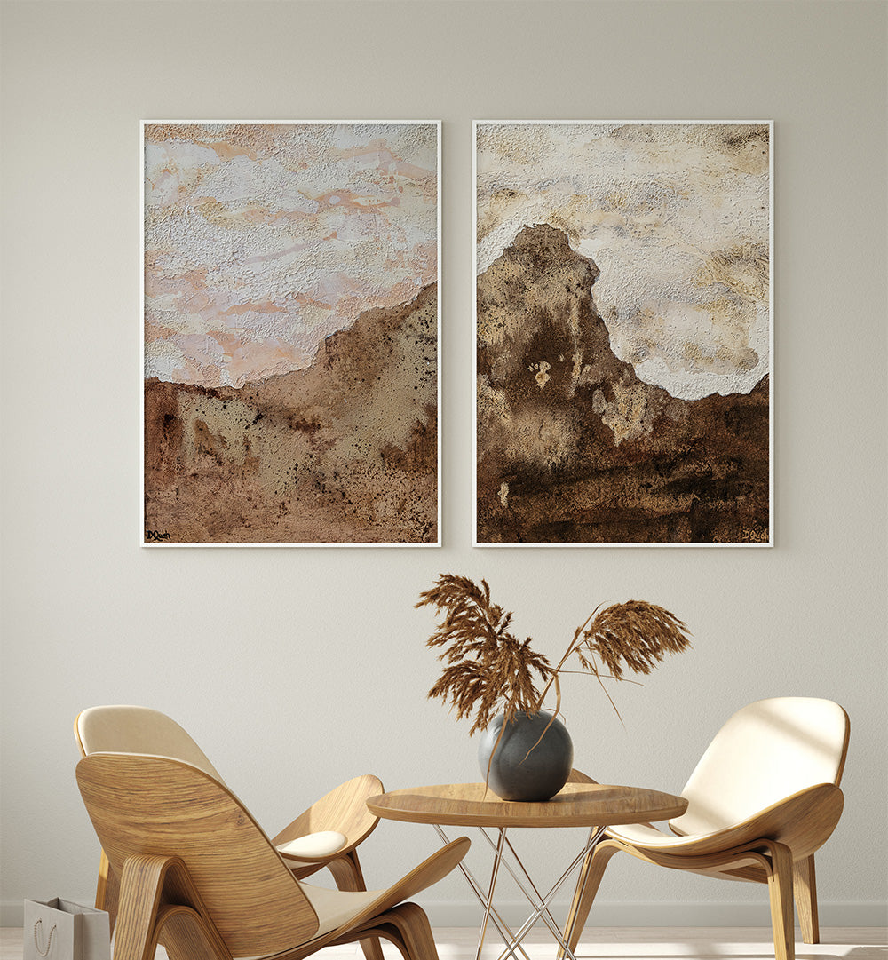 Two abstract wall art pieces above a wooden table with chairs in a room.