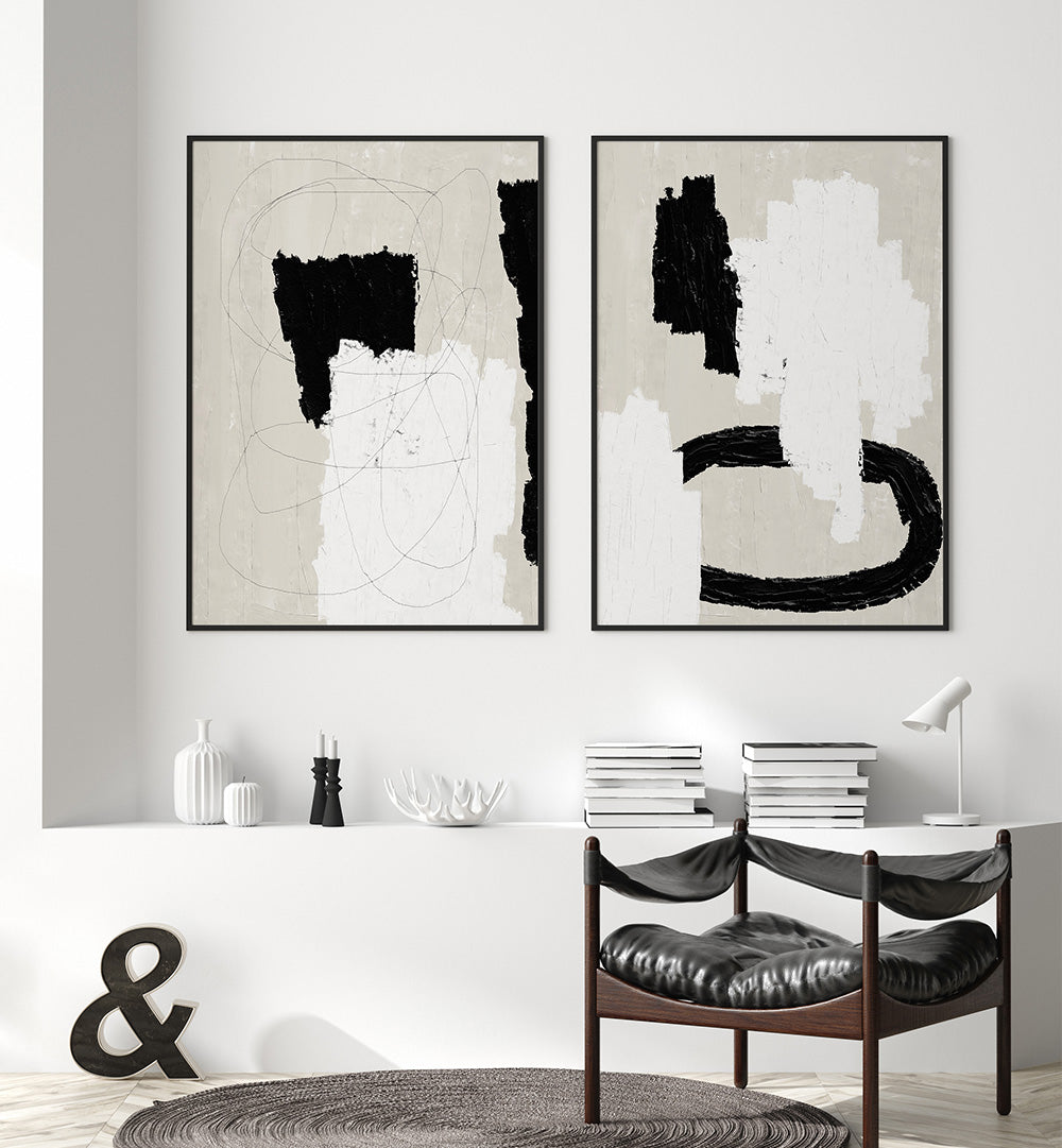 Two abstract art pieces on a wall above a dining table with chairs.
