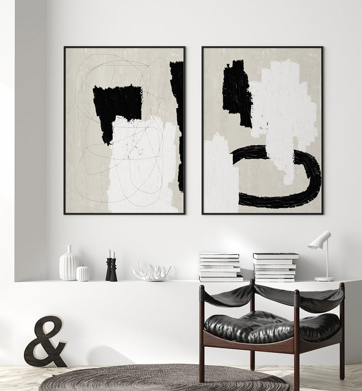 Two abstract art pieces on a wall above a dining table with chairs.