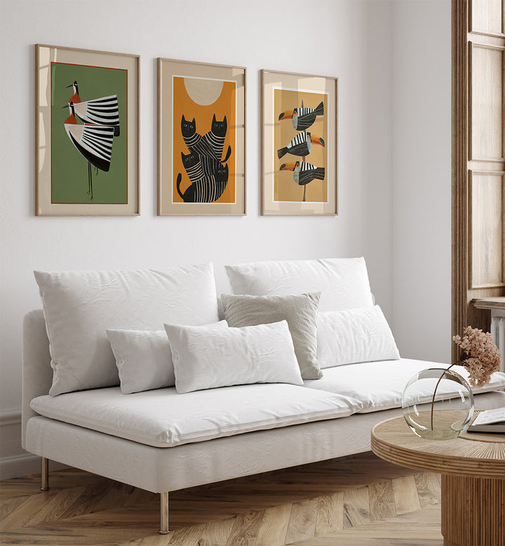 White sofa with decorative pillows in a living room with framed artwork on the wall.