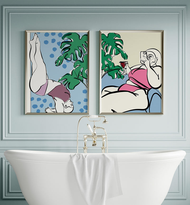 Two framed artworks on a wall above a white bathtub.