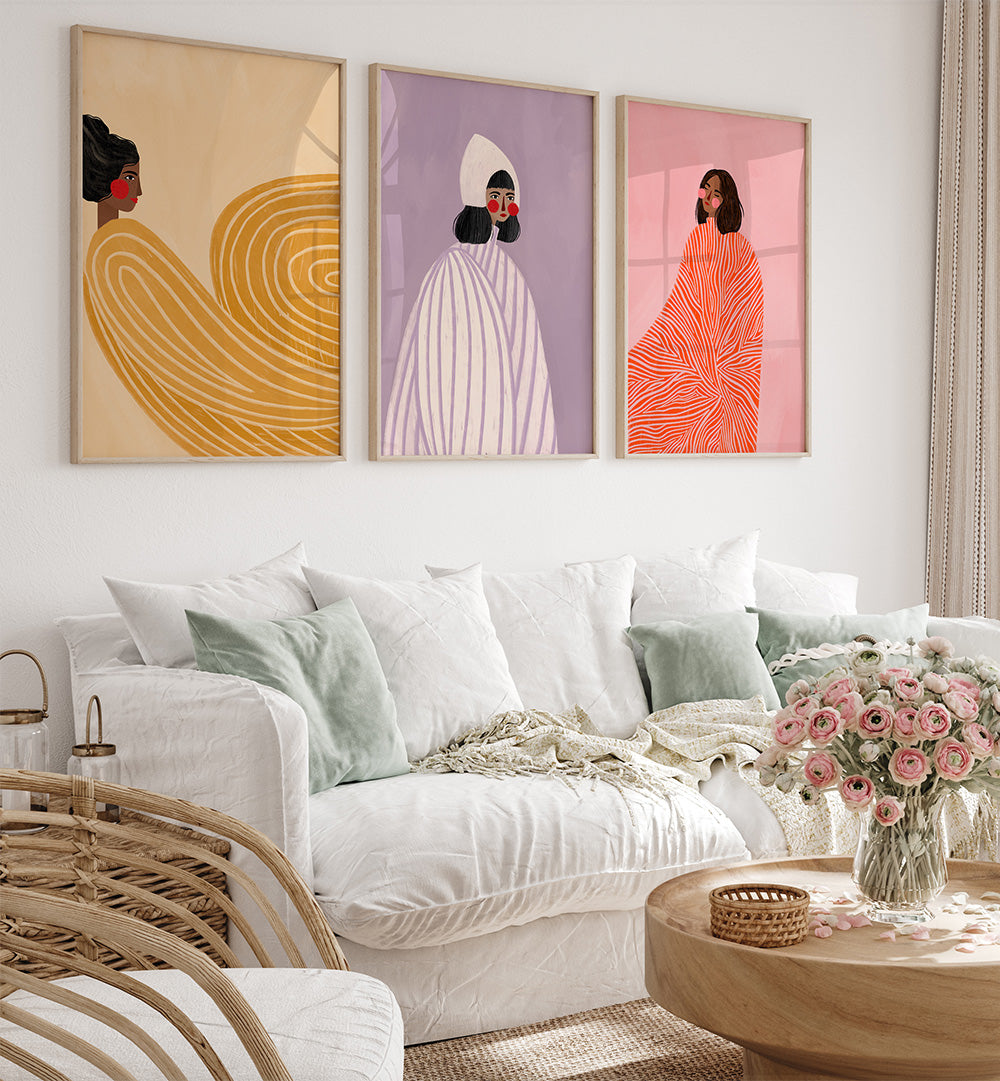 Living room with a white sofa, wicker chair, and three colorful wall art pieces.