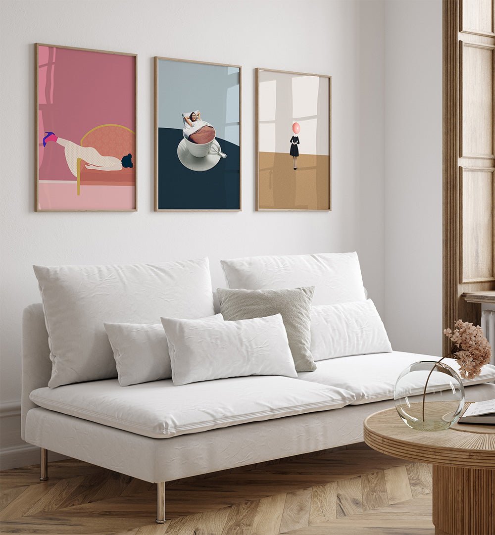 Modern living room with a white sofa, wooden coffee table, and three abstract art pieces on the wall.
