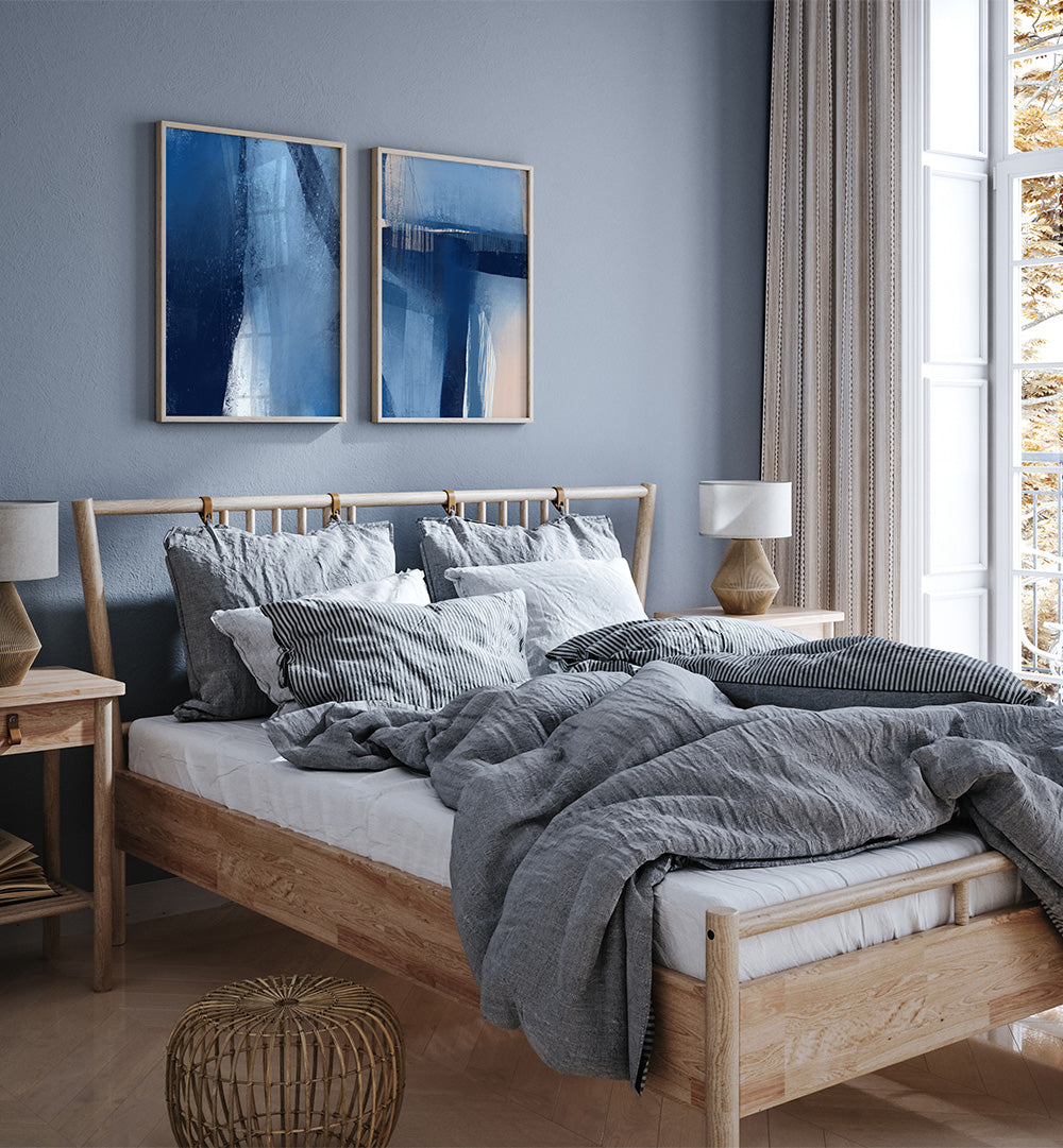 Cozy bedroom with wooden bed, gray bedding, and abstract wall art.