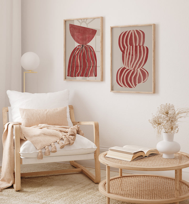 Living room with a wooden armchair, wicker coffee table, and abstract red artworks on the wall.
