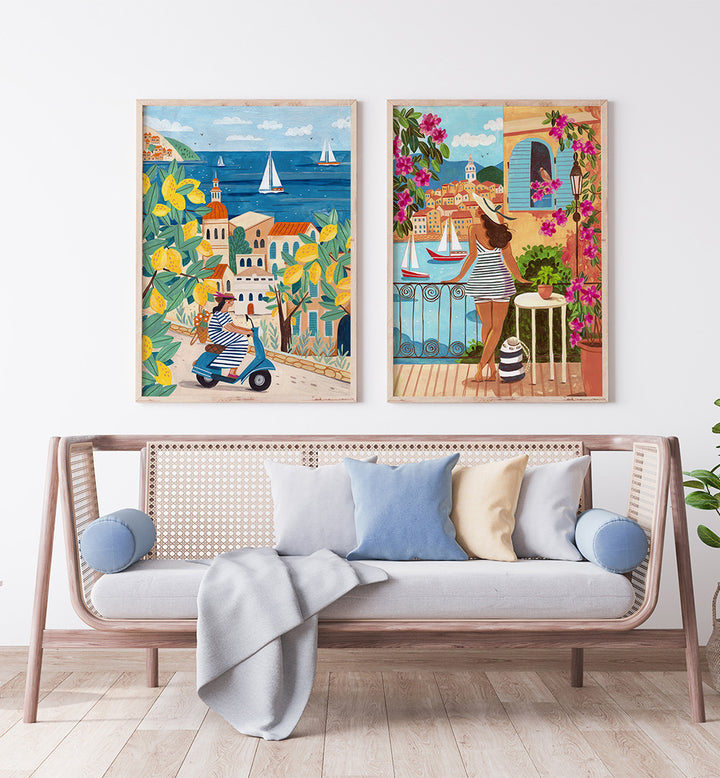 Two colorful framed artworks on a wall above a sofa with decorative pillows.