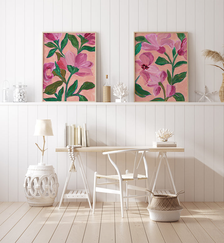 Floral artwork on a white wall with a table and chair below.