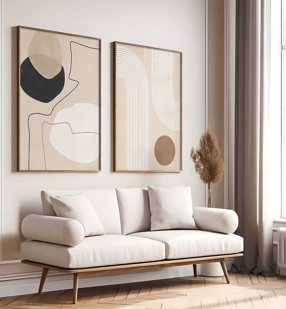 Modern living room with a white sofa, abstract art on the wall, and a vase with dried plants.