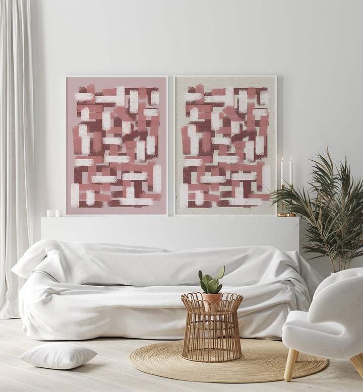 Modern living room with white sofa, abstract pink artworks, and a small table with a plant.