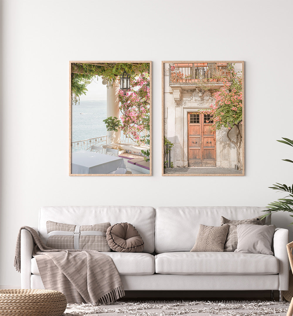Two framed prints of scenic views above a white sofa in a living room.