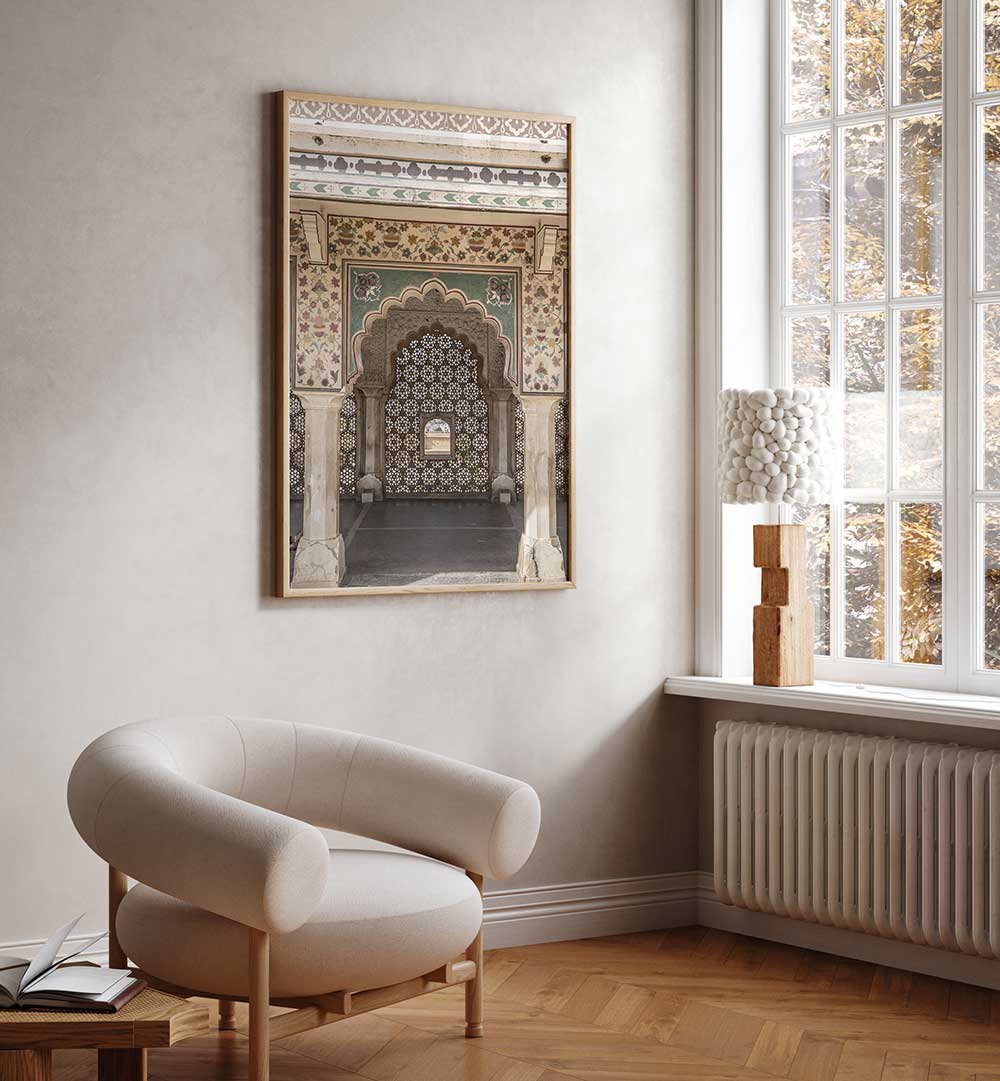 Framed ORNATE ARCHWAY , INDIAN ART PAINTINGS hung above a lounge chair in a minimalist sunlit room