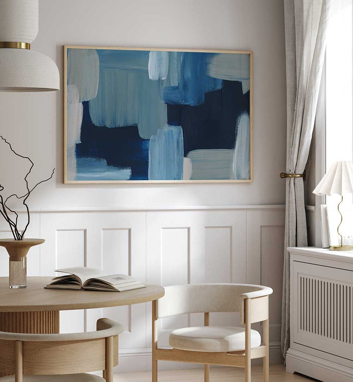 Blue framed BRUSH STROKES , ABSTRACT PAINTINGS hanging above table in modern neutral dining room