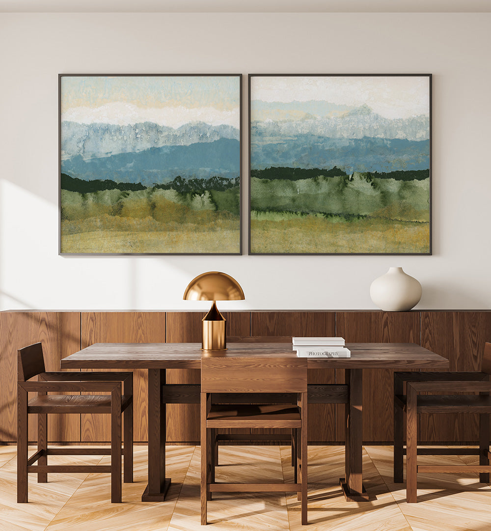 Dining room with wooden table and chairs, and two framed landscape paintings on the wall.