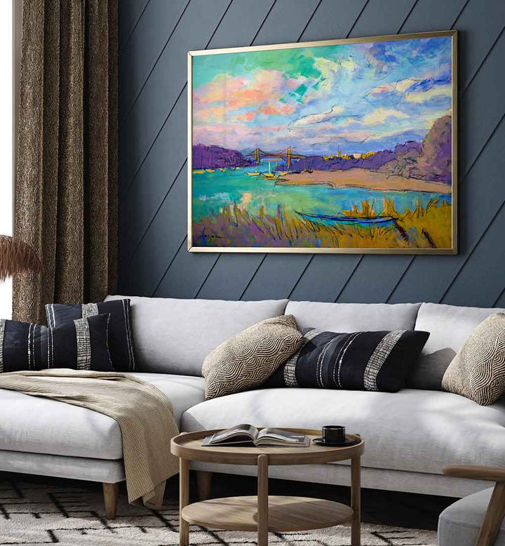 SERENE RIVER SKIES , LANDSCAPE PAINTINGS showing colorful river vista with bridge and boat above a modern living room sofa