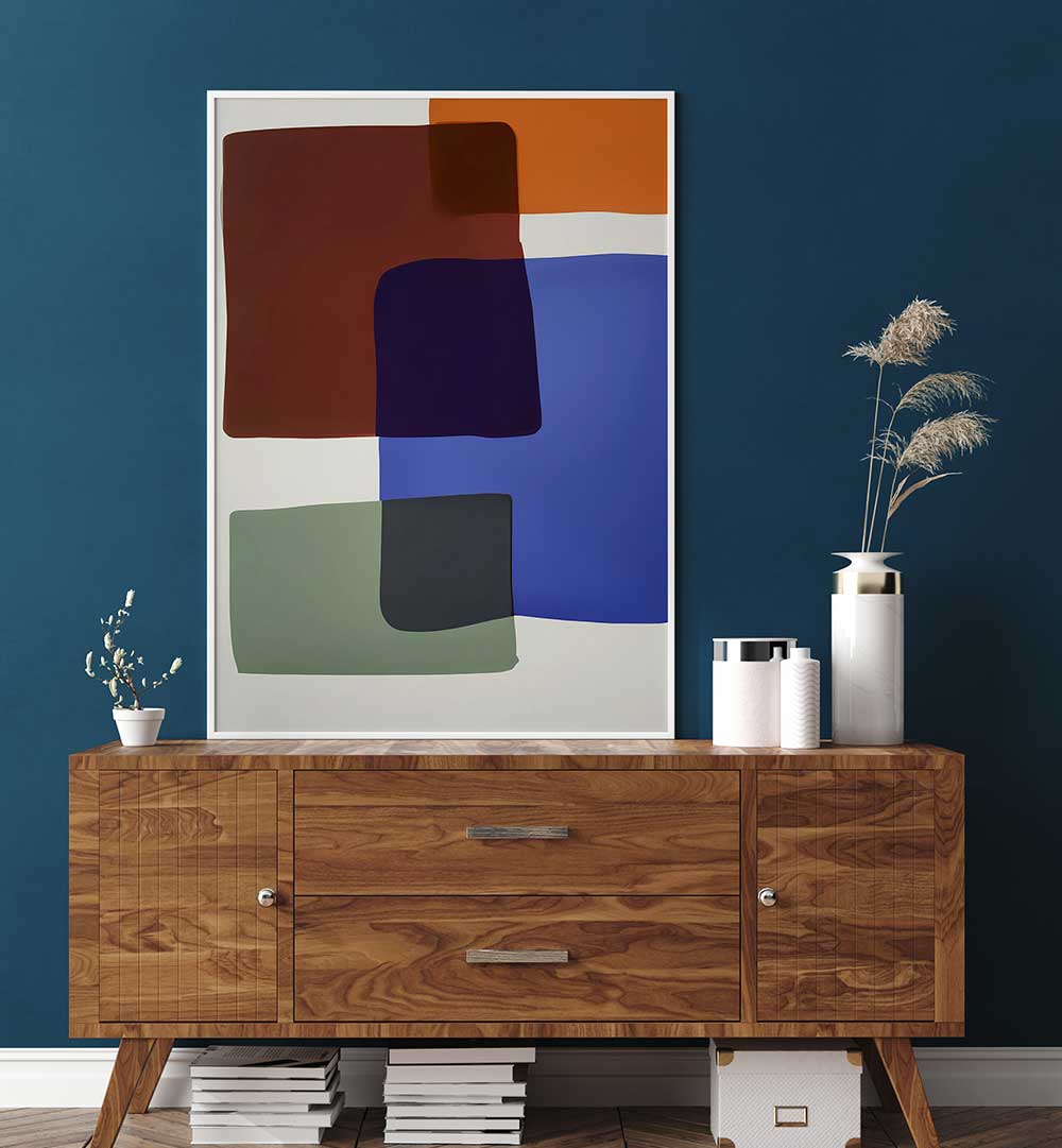 OUT OF THE BOX , ABSTRACT PAINTINGS featuring bold color blocks in blue, rust, green, and black on white backdrop above wooden sideboard