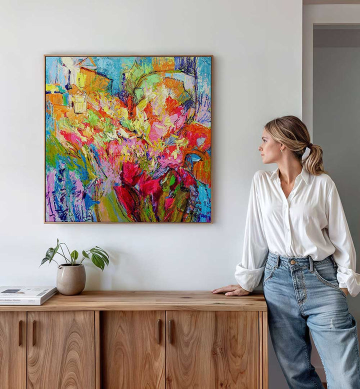 BRILLIANT BLOOM SCAPE , ABSTRACT PAINTINGS vibrant floral abstract canvas above wood console, woman viewing