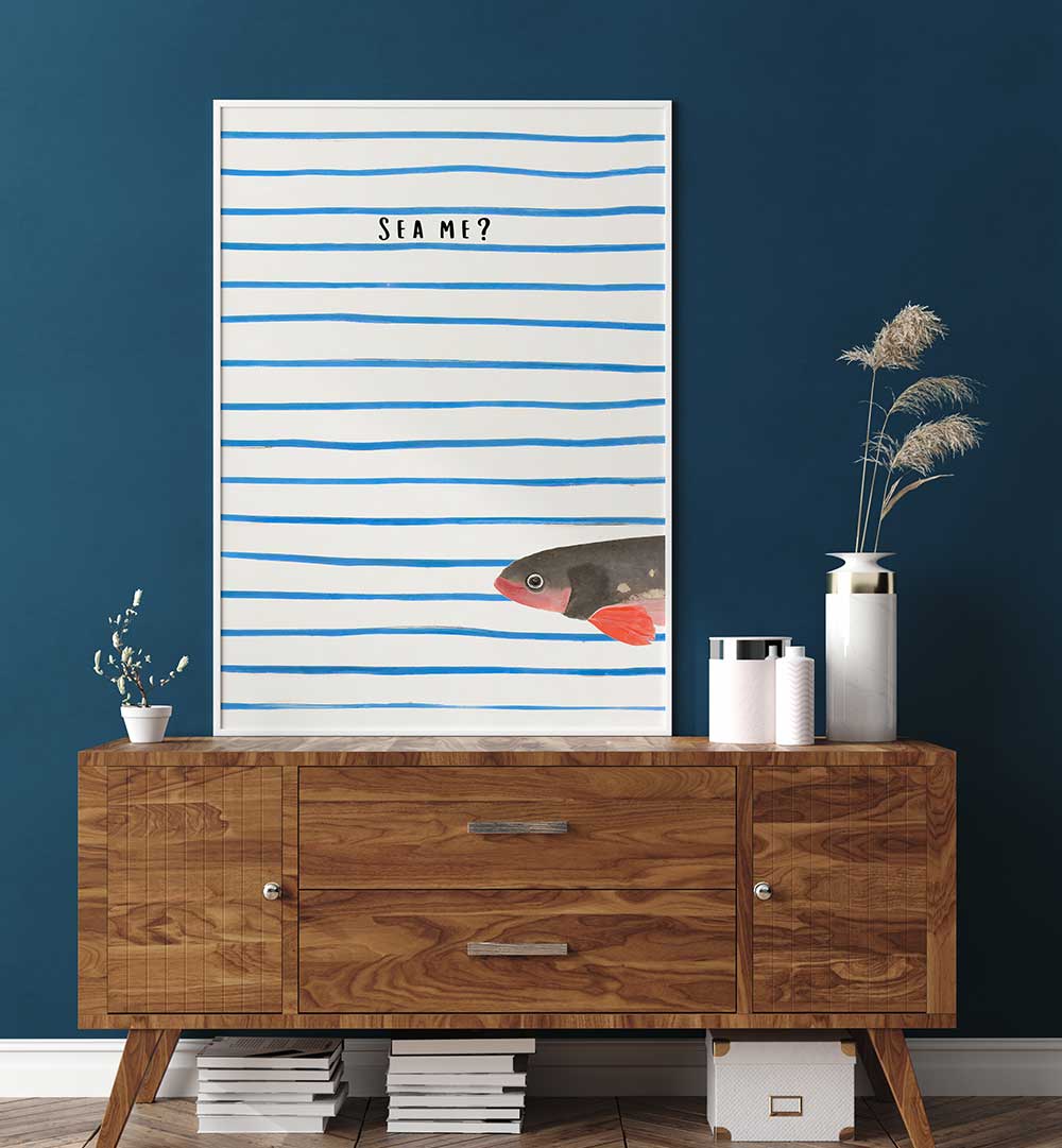 SEA ME , BEACH PAINTINGS featuring a fish and blue stripes above a wooden sideboard in a modern coastal room setting.