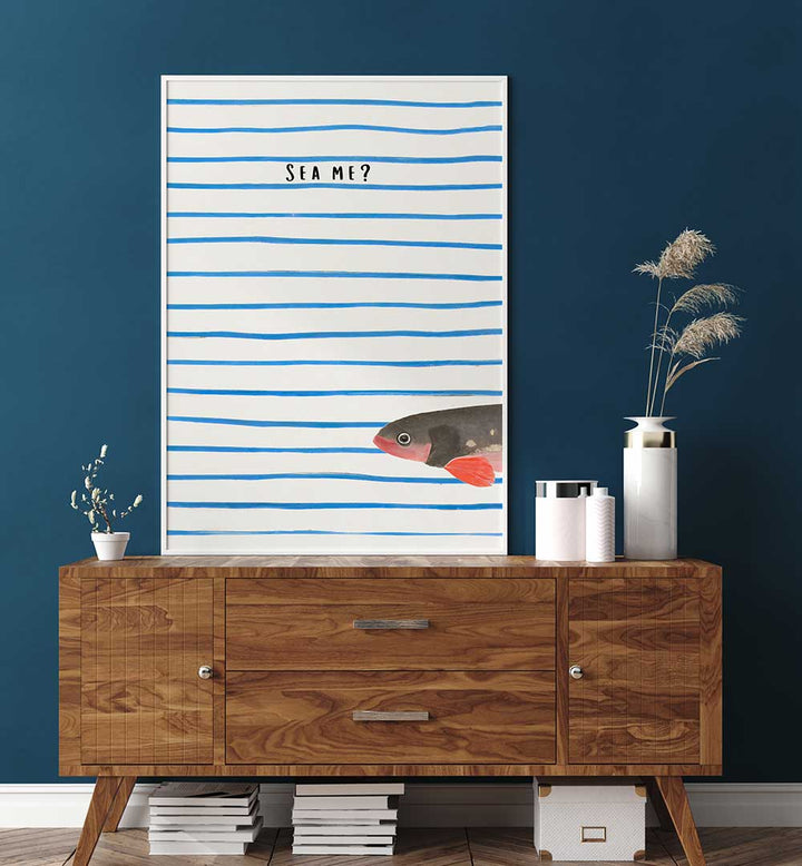 SEA ME , BEACH PAINTINGS featuring a fish and blue stripes above a wooden sideboard in a modern coastal room setting.
