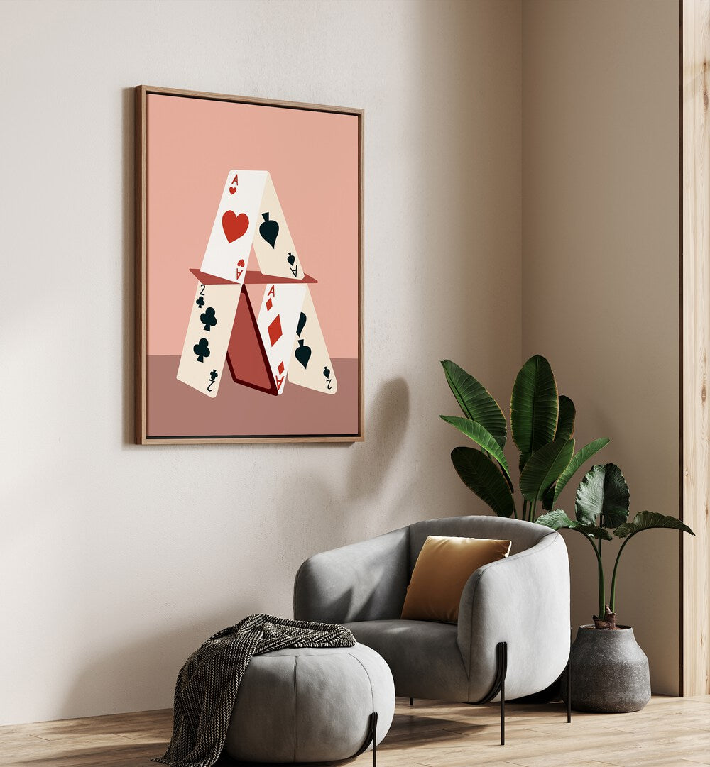 A House Made Of Cards By Uma Gokhale Gaming Poster in Oak Wood Floater Frame on a cream wall beside a sofa