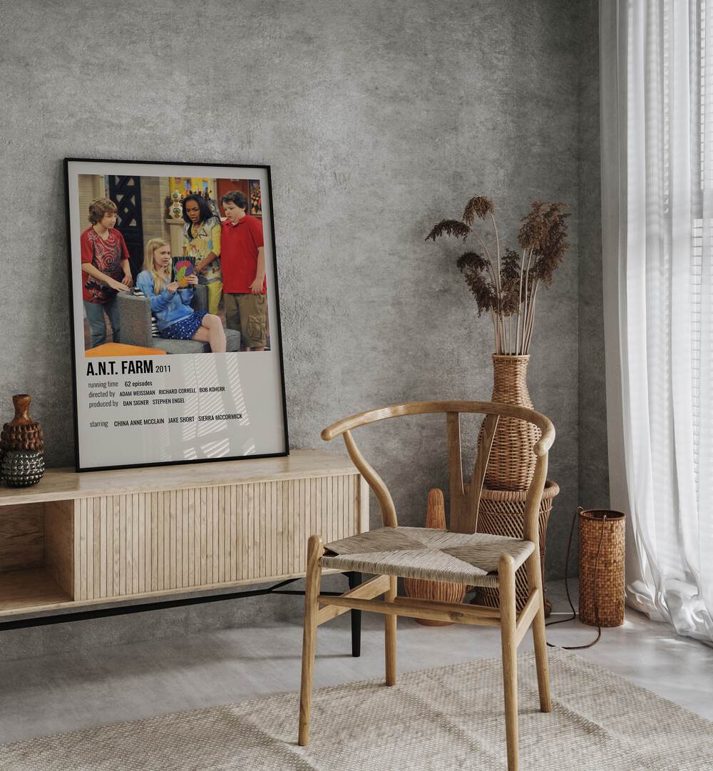 A N T Farm 2011 Movie Posters in Black Plain Frame placed on a table beside oakwood chair