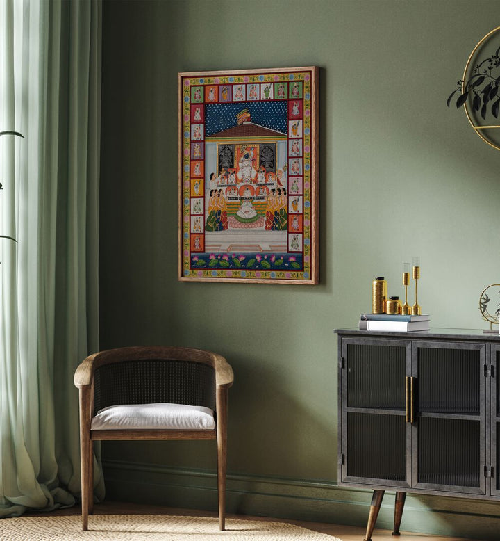 Annakut Pichwai Artwork Indian Art Painting Artwork in oakwood floater frame on a green wall above a brown chair