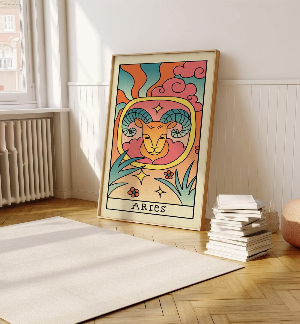 Aries Zodiac & Tarot Art Painting Artwork in plain oakwood frame on a wooden floor beside a stack of books