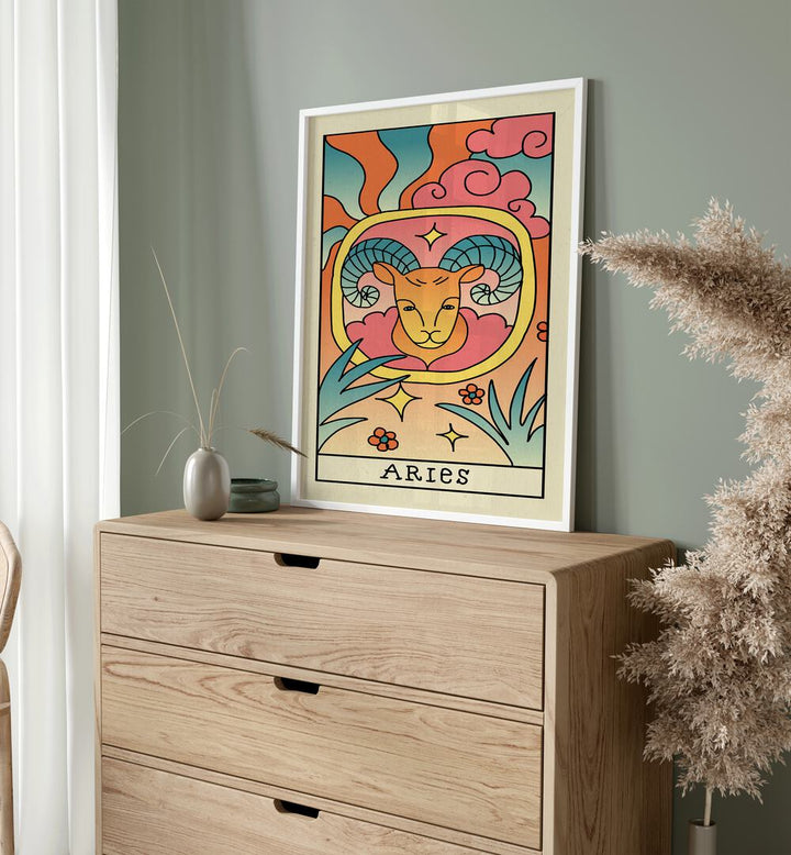 Aries Zodiac & Tarot Art Painting Artwork in plain white frame on a console table beside a pot