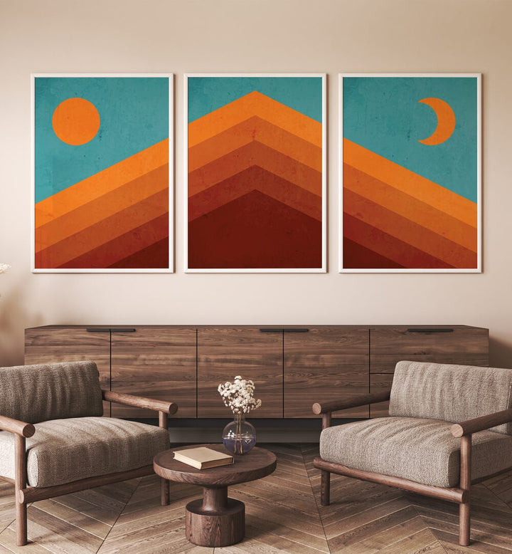 Abstract Mountain Sunrise Set Of 3 Paintings in White Plain Frame placed on a wall behind a console table