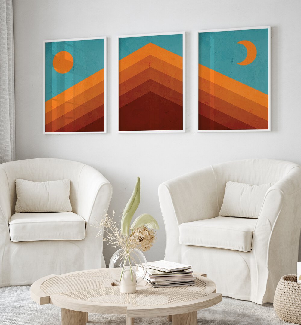 Abstract Mountain Sunrise Set Of 3 Paintings in White Plain Frame placed on a wall living room wall behind a sofa