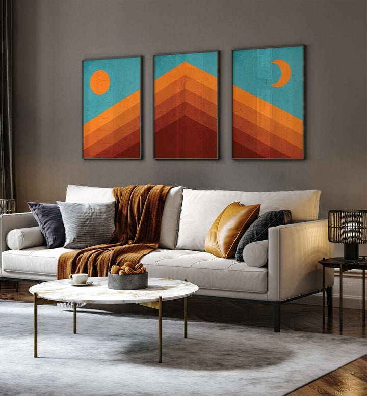 Abstract Mountain Sunrise Set Of 3 Paintings in Black Plain Frame placed on a wall living room wall behind a sofa