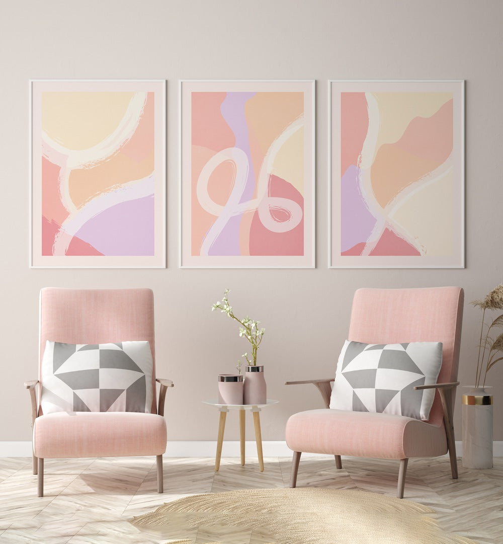 Abstract Ratios Set Of 3 Paintings in White Frame With Mount placed on a wall behind pink chairs