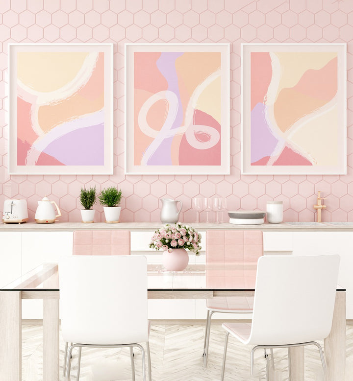 Abstract Ratios Set Of 3 Paintings in White Frame With Mount placed on a pink wall behind a kitchen counter and a dining table