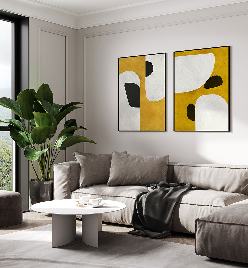 Modern living room with a gray sectional sofa, abstract art on the wall, and a plant.