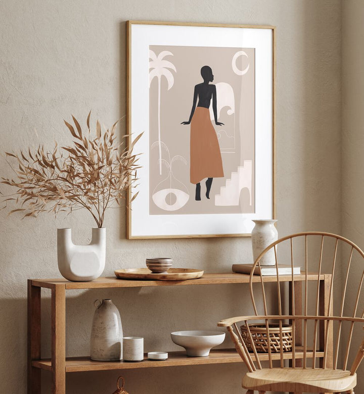 African Women By Ivy Green Women Illustration Paintings in Oak Wood Frame With Mount on a beige wall above a table