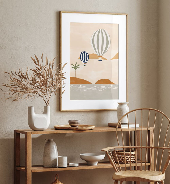 Airballoons In Dessert By Ivy Green Beach Prints in Oak Wood Frame With Mount on a cream colour wall above a table