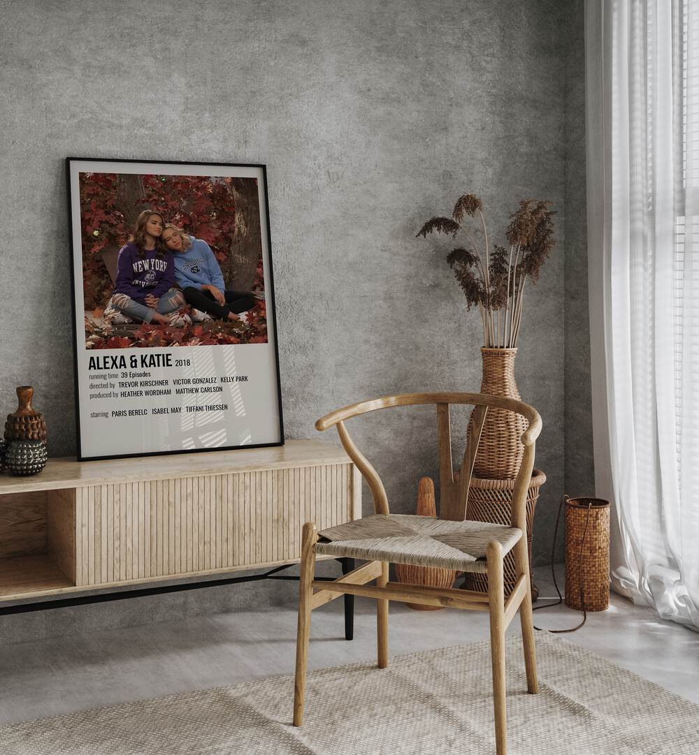 Alexa & Katie 2018 Movie Posters in Black Plain Frame placed on a table beside oakwood chair