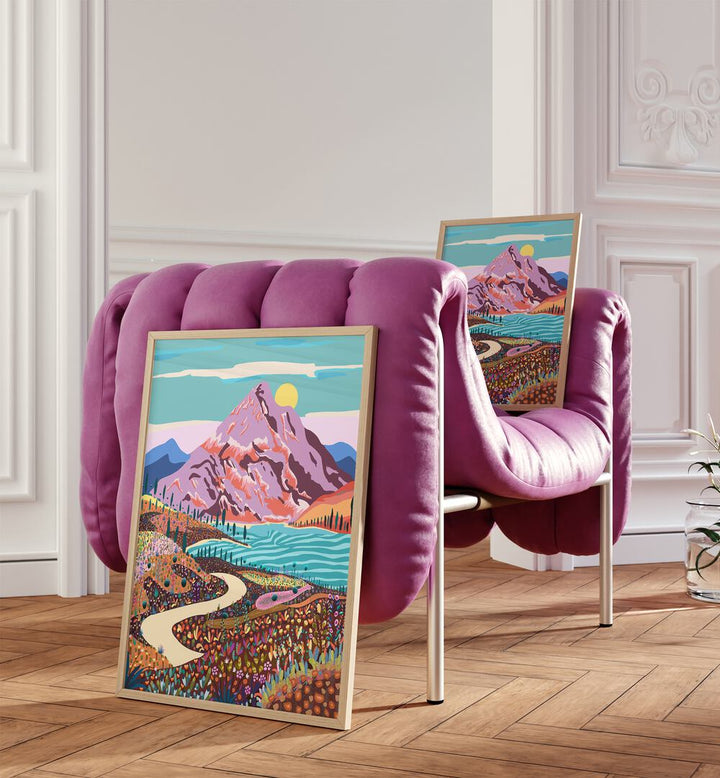 Alice In Wonder Valley By Uma Gokhale Landscape Art Prints in Oak Wood Plain Frame on a wooden floor beside a pink sofa and on a pink sofa