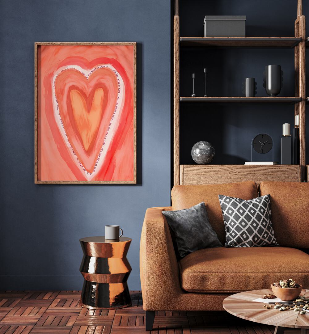 All You Need Is Love By Treechild Wall Art Prints in Oak Wood Plain Frame placed on a Blue Colored Wall near a Brown Sofa in the Living Room